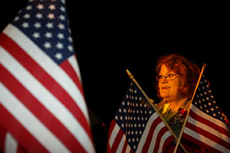 A woman waits on a cold winter morning for a loved one to step off a plane after serving in Iraq with the Indiana National Guard.